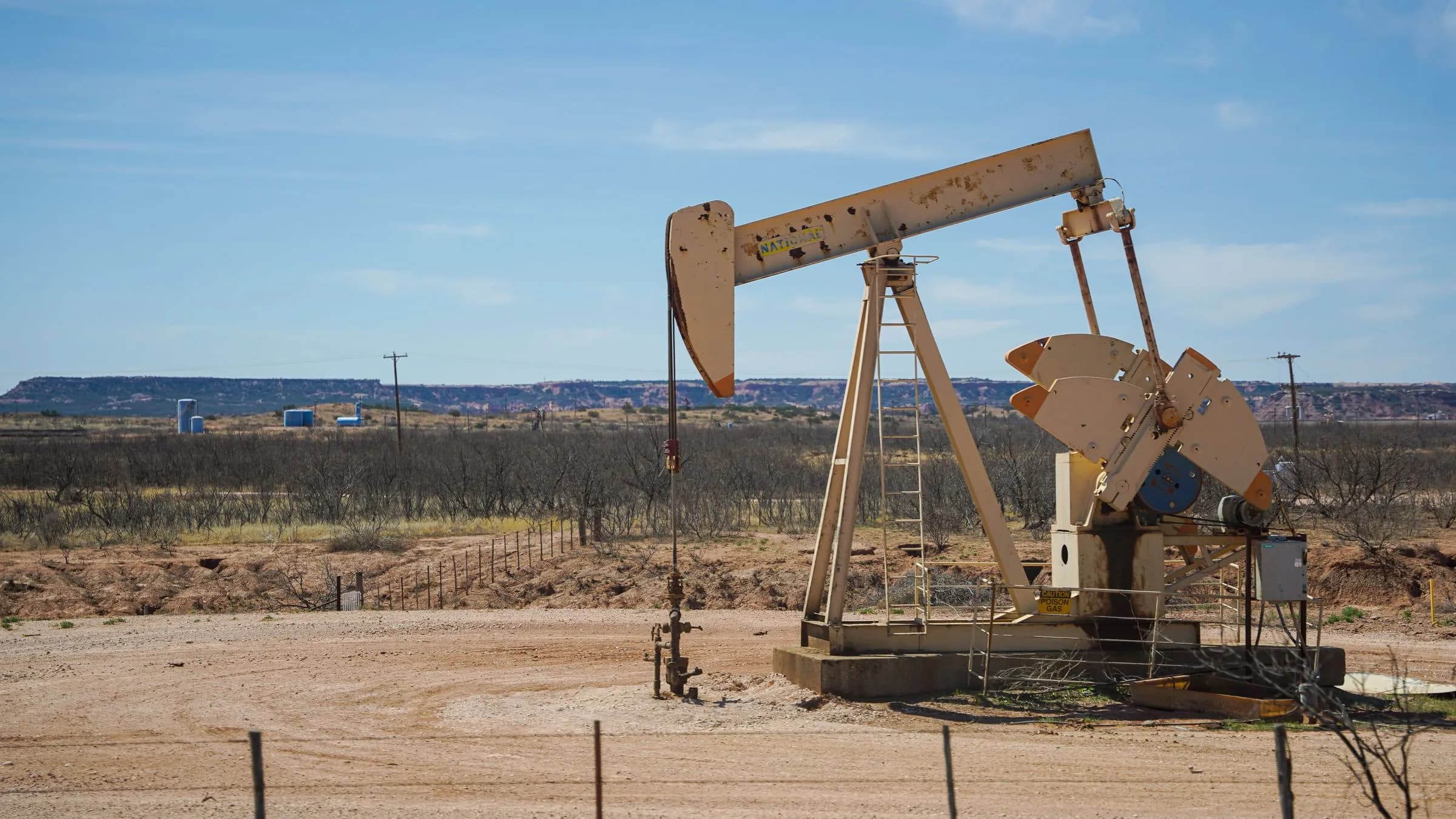 A pumpjack working an oil well in the desert under a clear sky